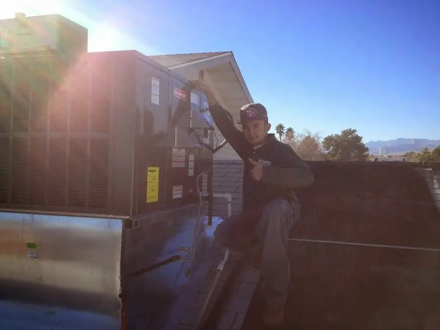 HVAC technician performing Heat Pump Repair on a rooftop unit in Brunswick
